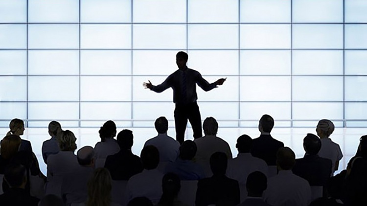 Speaker on stage talking to a crowd